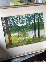Framed watercolor painting of a lakeside landscape with trees and foliage.