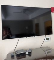 Samsung flatscreen TV mounted on wall with console surface below