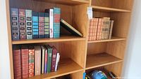 Several shelves of hardcover books including classic literature and biography.