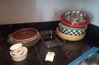 Overview of stacked mixing bowls, pie pans, and rectangular glass baking dish on a kitchen counter