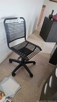 Full view of the plastic slat office chair showing wheeled base and slat design