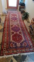 Full length view of the red and blue runner rug laid out on tiled floor