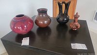 All four vases displayed on black surface