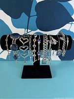 Full lot of multiple sterling silver bracelets placed on a black velvet display stand, showing overall range and styles in the set.