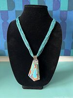 Full front view of necklace and pendant on display bust