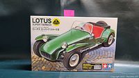 Box front showing finished model of green Lotus Super 7 Series II with red interior on paved background.