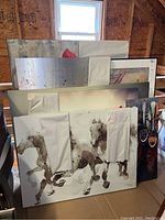 Overall view of seven stacked wall art pieces including abstracts, floral, horses, spice spoons, and framed drawing
