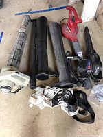 Wide view showing three blower vacs and multiple tubes laid out on floor
