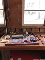 Workbench with assortment of hand tools including ratchet set, files, screwdrivers, and a level