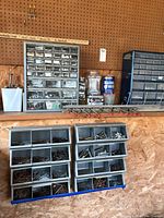 Storage drawers filled with assorted screws and nails of various sizes and types.