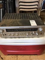 Front and top view of Sony STR-6065 receiver showing silver faceplate, control knobs, and tuning window.