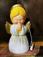 Angel blow mold light with yellow hair, gold halo and wings, white and yellow robe, showing paint loss and untested condition with attached power cord.