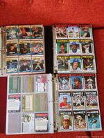 Open binder showing baseball cards including teams: Astros, Twins, Phillies, Red Sox, Padres, Brewers, Pirates, Rangers, Indians, White Sox, Yankees