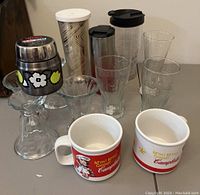 Overview of all cups, tumblers, and glasses arranged on table showing variety and design details