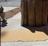 View of the gold Berber carpet runner lying flat on concrete, showing its texture and backing.