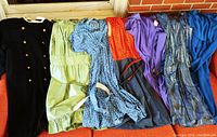 Seven dresses laid out showing color, style, and condition overall