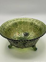 View of the iridescent green carnival glass bowl showing scalloped edges, rose pattern and ribbed design