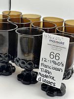 Close view of multiple glasses from a side angle highlighting the uniformity, height, and stout shape.