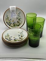 Photo of six Mikasa side plates stacked with three emerald green glasses beside them, showing the overall set.