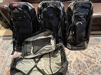 Four MEC Fast Track rolling suitcases upright and one open showing overall lot setup