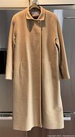 Front view of camel cashmere coat on hanger
