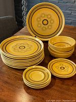 Stack of plates and bowls showing the full set with yellow honeycomb retro pattern.