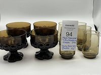 Set of 4 smokey brown footed dessert coupes and 6 tawny juice glasses arranged side by side