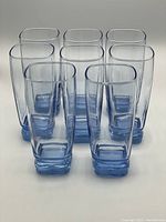Front view of the 8 blue cooler glasses arranged in a group showing their size, shape, and color.