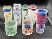 All six glasses shown front-facing with drink names and world's fair graphics.