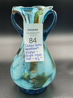 Front view of Italian hand-blown glass pitcher showing aqua blue coloration and four spouts.