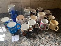 Front view showing various mugs including branded, floral, holiday, and solid colors.