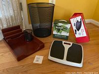 Photo of six items on floor including wooden desk organizer, pencil holder, mesh trashcan, digital scale, Auto Power Vac in red and white box, and ResistAll NG Customer Care Kit in green box.