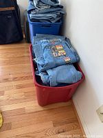 Bins of folded men's jeans size 28x32 showing various blue denim pairs including Wrangler and Levi's.