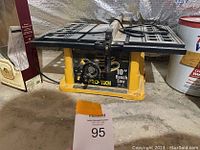 Front view of Pro-Tech 10-inch bench saw placed on a concrete floor with some dust and surrounding items.