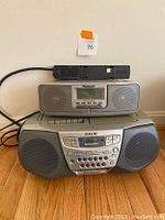 Front view of stacked Panasonic alarm radio on top of Sony CD/cassette player with power strip on top