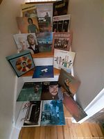 Photo showing 18 vinyl record albums arranged on stairs, titles and artists visible including Lionel Richie, Running Scared, Belafonte