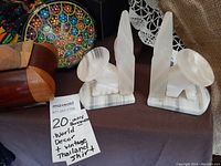 Close-up image showing pair of carved stone Mexican bookends alongside the wooden trinket box and colorful pottery dish.