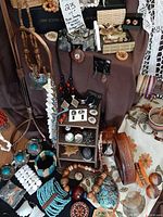 Full lot arrangement showing various vintage boho jewelry items in wooden shelves, necklace display, and bracelets on table.