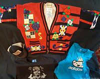 Overview of clothing items laid out: NO!JEANS red sweater, two Adidas T-shirts and two caps