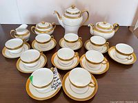 Overall view of 12 cups with saucers, coffee pot, teapot, sugar bowl and creamer