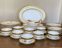 Full arrangement of plates, cups, saucers, platters, serving bowl, gravy boat on tabletop