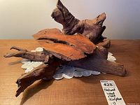 Natural wood root sculpture shown from a top-side angle, highlighting the gnarled root extensions and natural surface textures.
