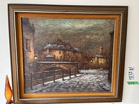 Frontal view of framed oil painting showing snowy village scene