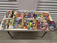 Full view of the comic book collection spread on a table showing front covers of approximately 28 issues.