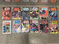 Photo showing a collection of Star Wars comics laid out flat on a concrete floor including Marvel titles and other Star Wars editions.