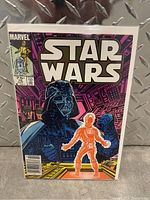 Front cover of the Star Wars comic showing Darth Vader and an orange figure, in protective plastic sleeve.