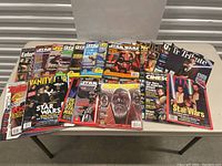 Photo showing a spread of around 26 magazines laid out on a table featuring Star Wars, Star Trek and other sci-fi themes including Entertainment Weekly, Vanity Fair, Starlog, and others.