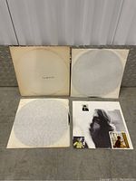 Gatefold sleeve, two vinyl records in white paper sleeves, and fold-out poster displayed