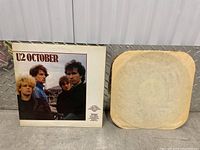 Front view of the U2 October vinyl album cover with band photo and separate inner paper protective sleeve.