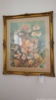 Full view of the framed acrylic floral painting hanging on a wall showing the soft pastel colors and details of the flowers.